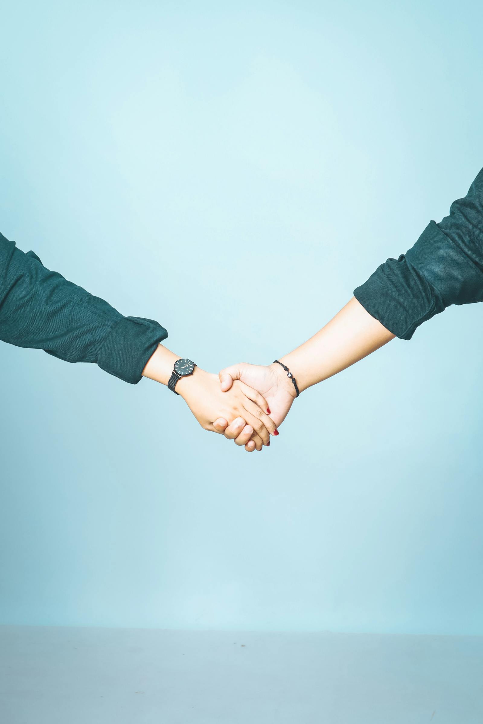 free-photo-of-holding-hands-against-blue-background